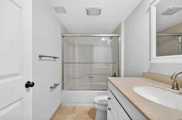 a bathroom with a granite countertop sink toilet and shower