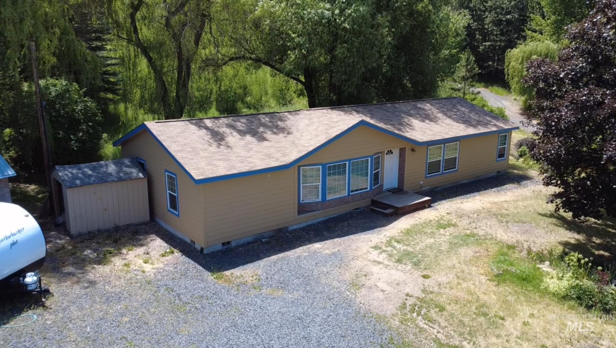 1089 Wallen Road Moscow, ID 83843 - Photo 42 of 43 View of front facade with gravel driveway, crawl space, a shed, roof with shingles, and a forest view