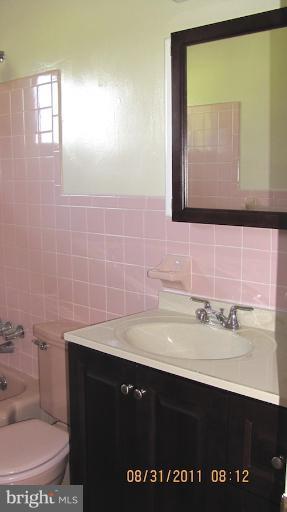 7116 Minna Road Gwynn Oak, MD 21207 - Photo 1 of 12 a bathroom with a sink a toilet and mirror