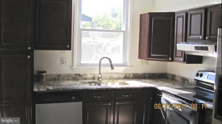 7116 Minna Road Gwynn Oak, MD 21207 - Photo 3 of 12 a sink with granite countertop a cabinets and a window