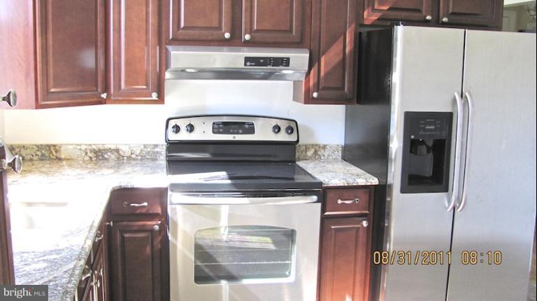 7116 Minna Road Gwynn Oak, MD 21207 - Photo 6 of 12 a kitchen with a stove and a refrigerator