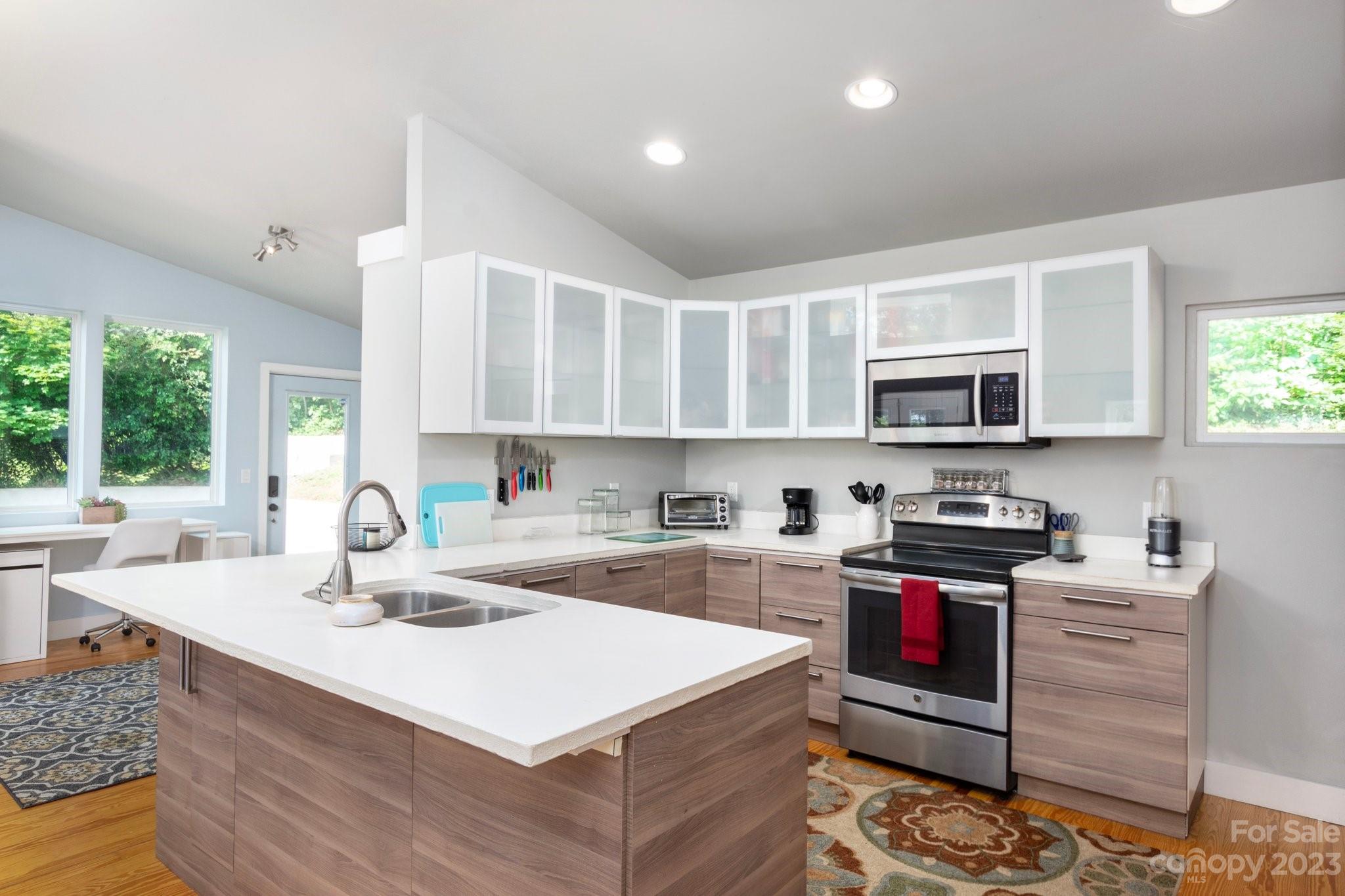 43 Kirkman Road Asheville, NC 28805 - Photo 10 of 27 a kitchen with stainless steel appliances kitchen island granite countertop a sink a stove and a microwave