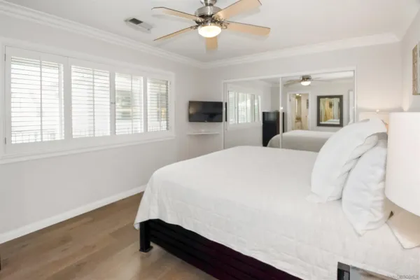 a bed sitting in a bedroom and chandelier next to a window
