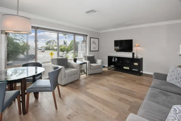 a living room with furniture a flat screen tv and a large window