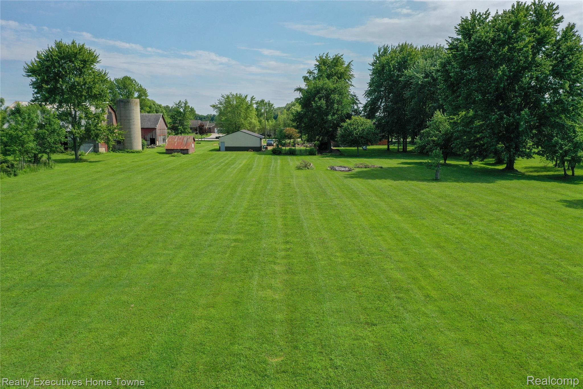 8728 Rynn Road Avoca, MI 48006 - Photo 47 of 53 Expansive green lawn with mature trees and visible outbuildings