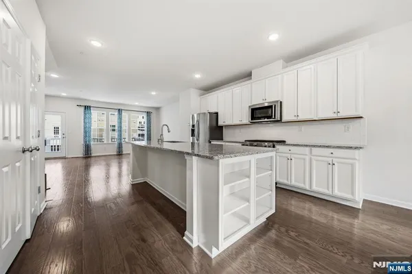 a kitchen with white cabinets and stainless steel appliances