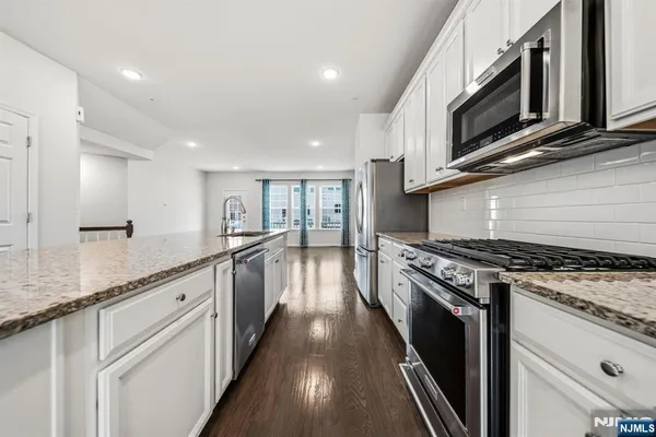 a large kitchen with stainless steel appliances granite countertop a stove and a sink