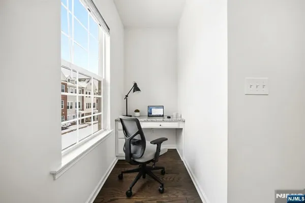 a view of a workspace with furniture and a window