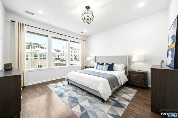 a spacious bedroom with a bed and wooden floor