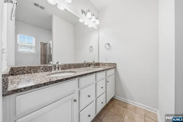 a bathroom with a granite countertop sink and a mirror