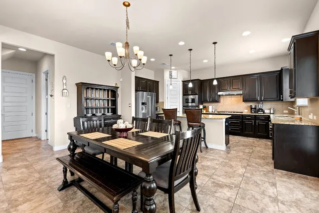 a view of a dining room and livingroom with furniture wooden floor a chandelier
