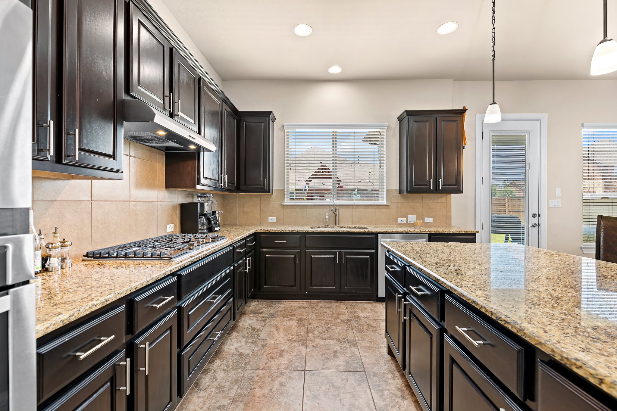 3501 Great Knot Pass Pflugerville, TX 78660 - Photo 15 of 40 a large kitchen with stainless steel appliances granite countertop a stove sink and cabinets