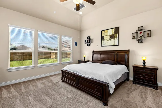 a spacious bedroom with a bed and a chandelier