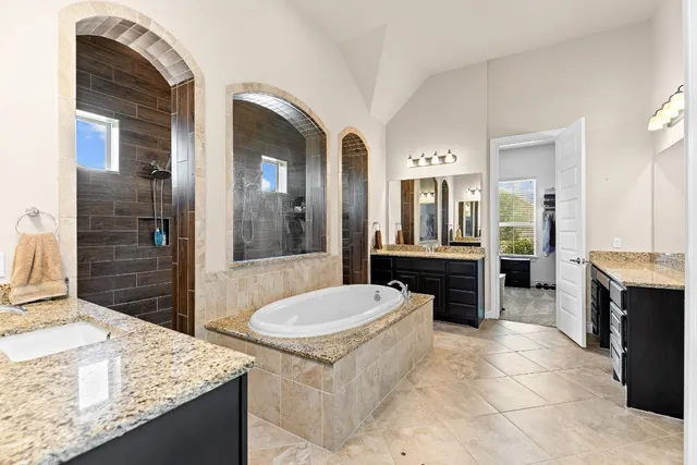 a spacious bathroom with a granite countertop sink and a mirror