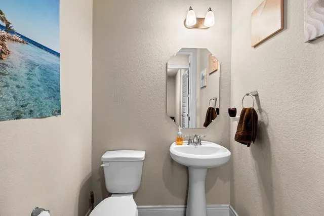 a bathroom with a toilet a sink and mirror
