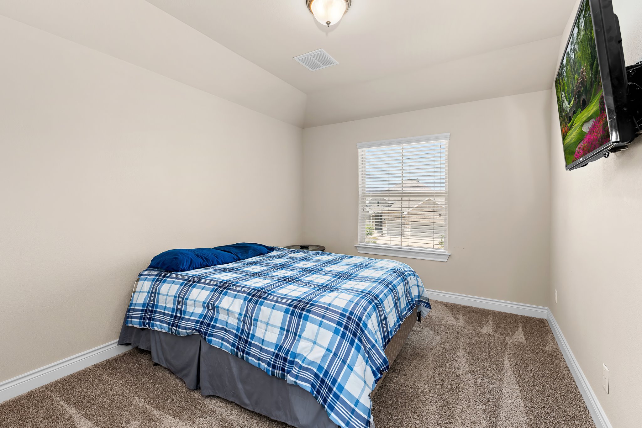 3501 Great Knot Pass Pflugerville, TX 78660 - Photo 29 of 40 a bedroom with a bed and a flat tv screen on a dresser