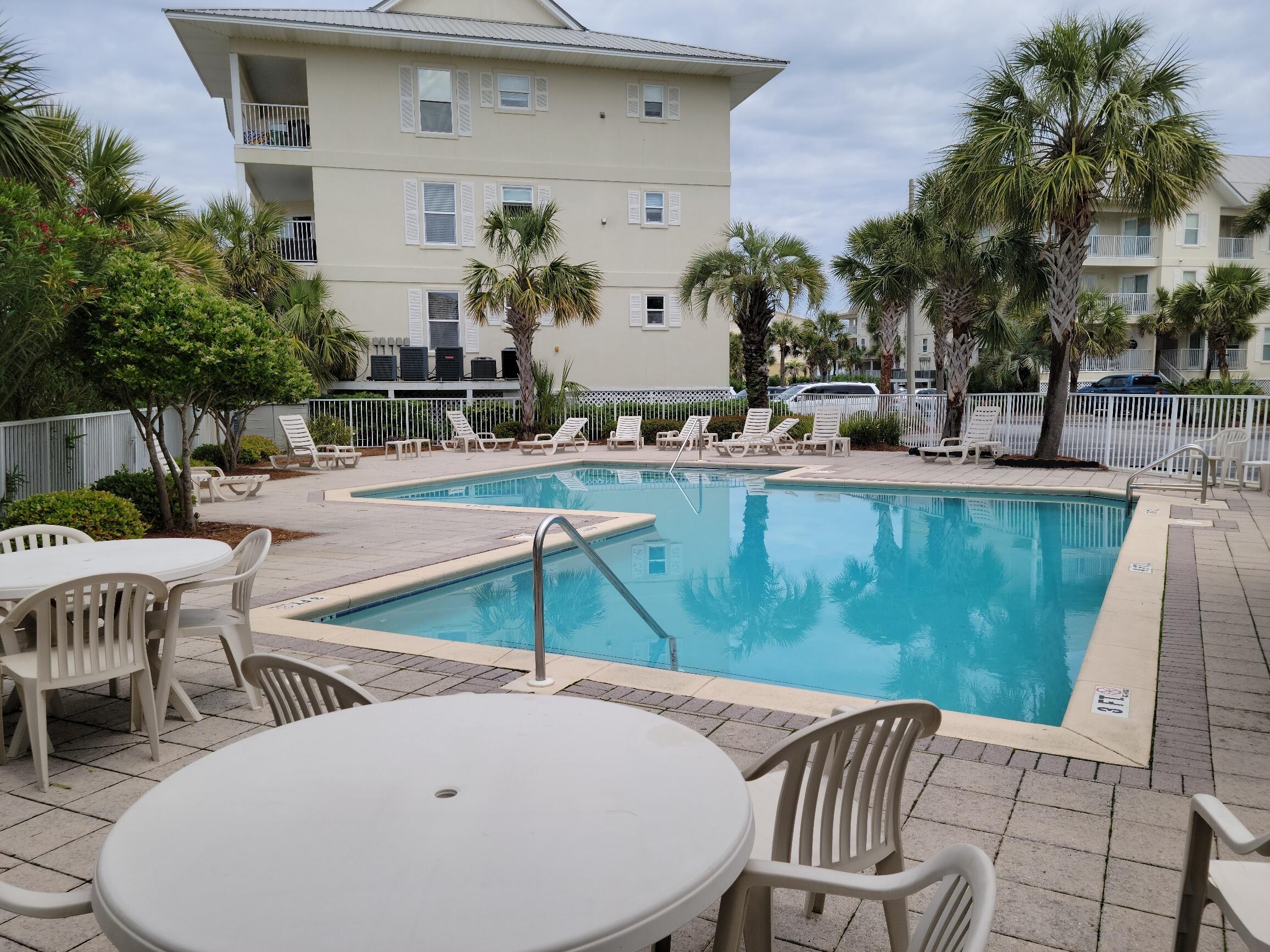8436 Gulf Boulevard, Unit 423 Navarre, FL 32566 - Photo 2 of 7 a view of a patio with table and chairs and potted plants