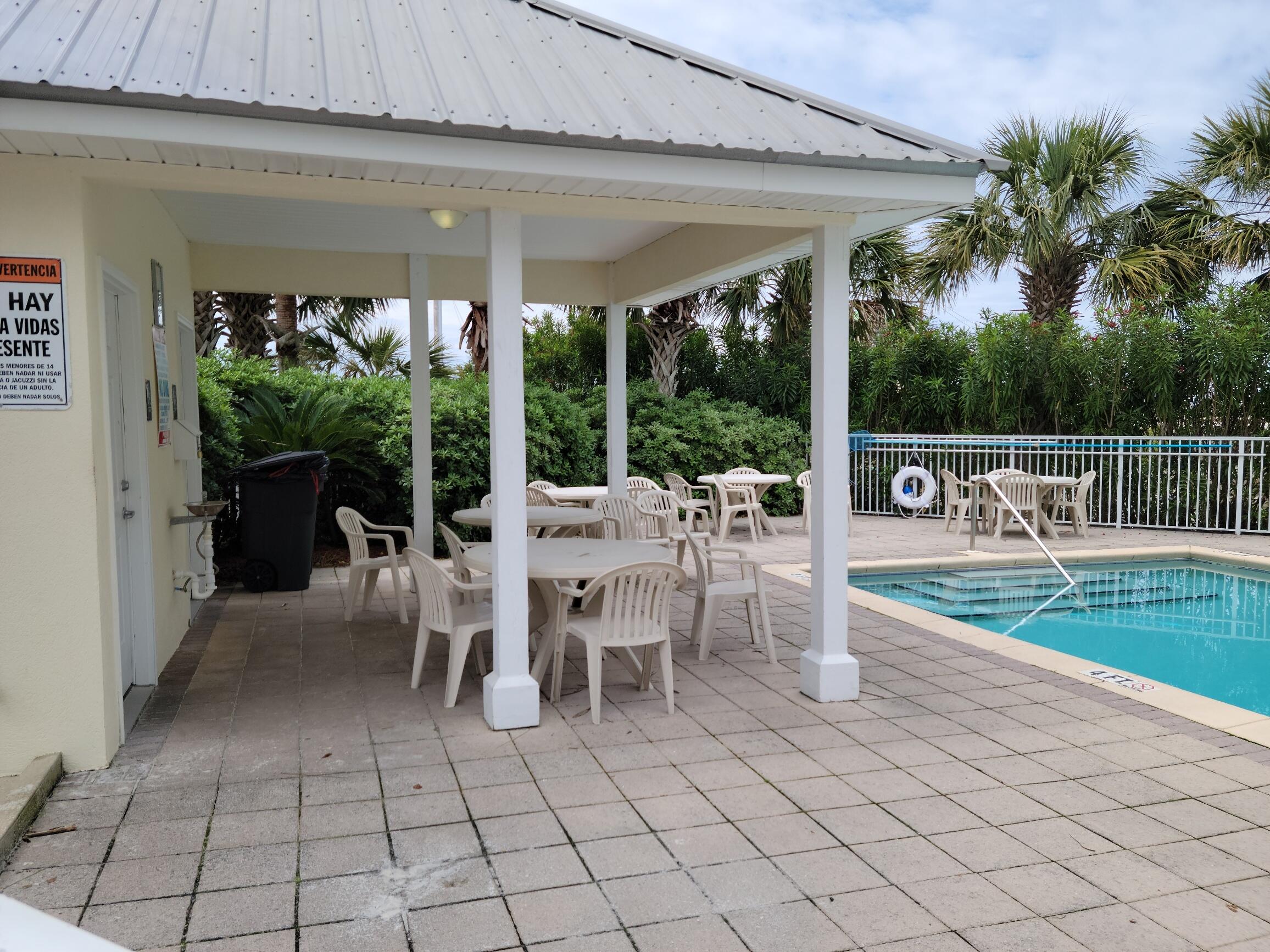 8436 Gulf Boulevard, Unit 423 Navarre, FL 32566 - Photo 3 of 7 a view of a patio with dining table and chairs