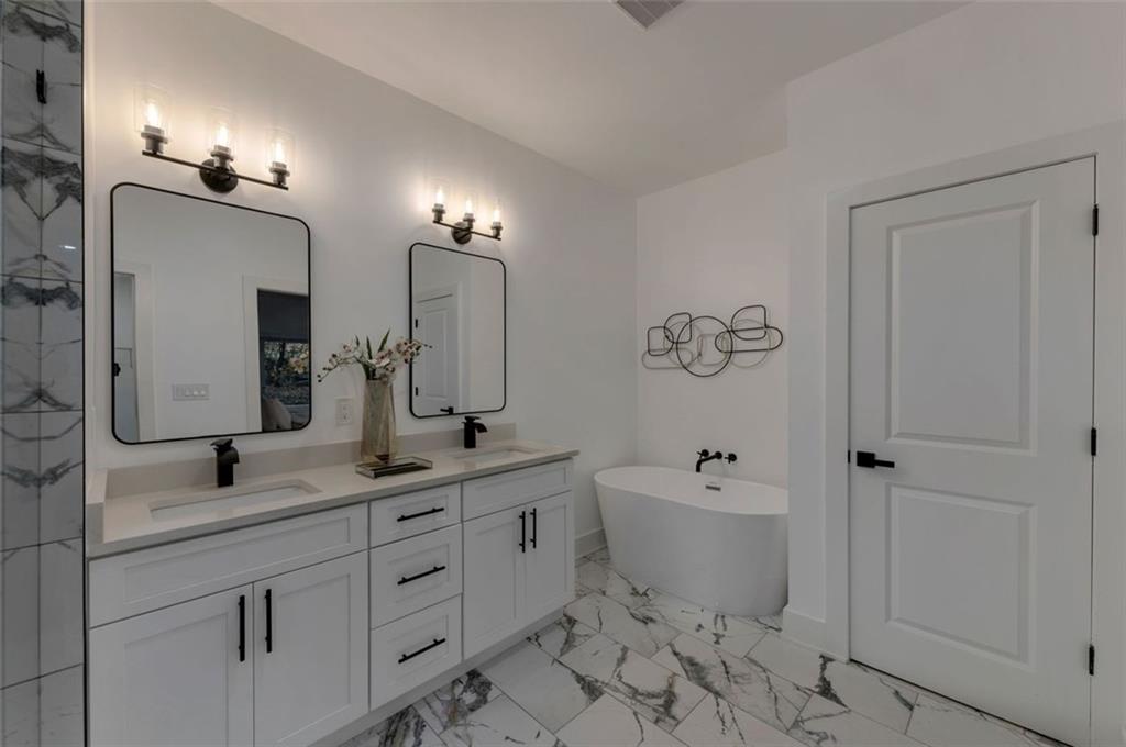 208 Watson Circle Southeast Atlanta, GA 30317 - Photo 27 of 45 a bathroom with a double vanity sink a toilet a mirror and shower