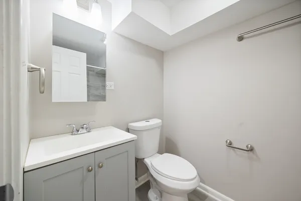 a bathroom with a sink toilet and a mirror