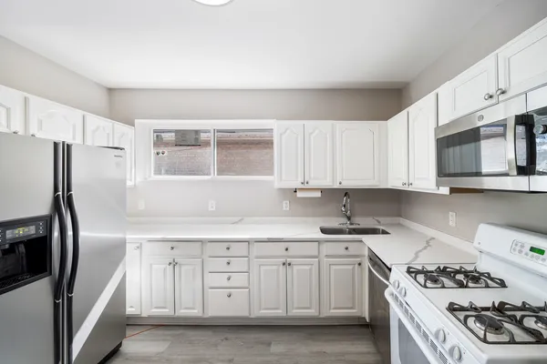 a kitchen with stainless steel appliances granite countertop a sink stove and refrigerator
