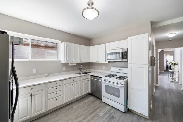 a kitchen with white cabinets stainless steel appliances and sink