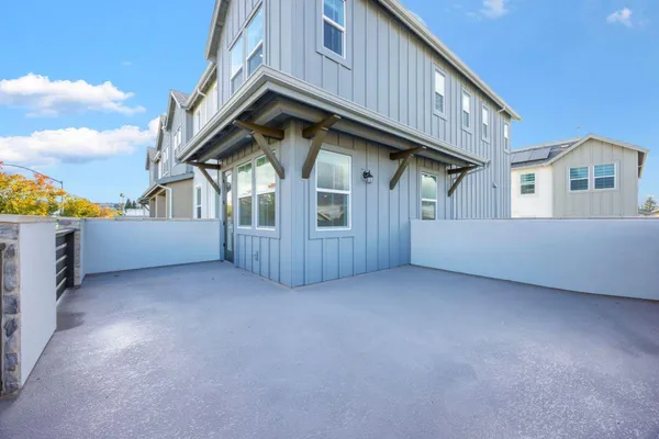 a view of backyard of house with wooden deck and entertaining space