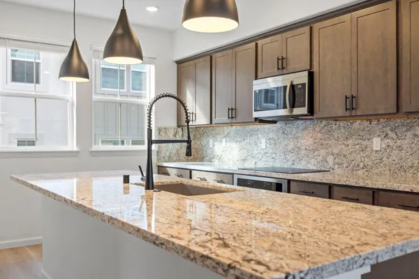 a kitchen with stainless steel appliances granite countertop a sink and a microwave