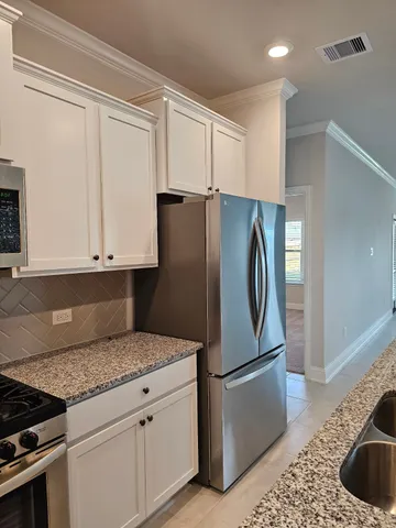 a kitchen with granite countertop a refrigerator and a sink