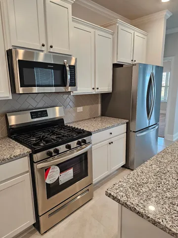 a kitchen with granite countertop cabinets and steel stainless steel appliances