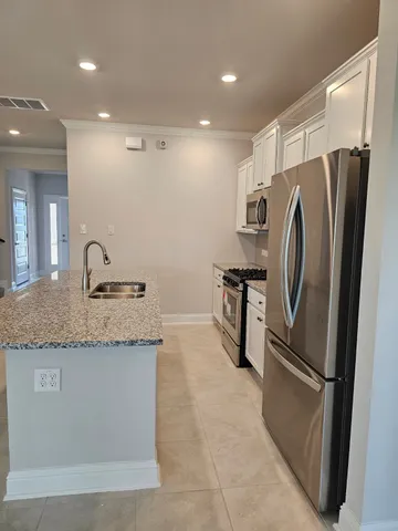a kitchen with stainless steel appliances granite countertop a refrigerator and a sink