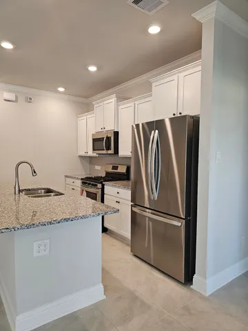 a kitchen with stainless steel appliances granite countertop a refrigerator a sink a stove a microwave and island