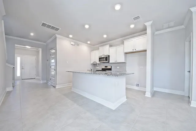a view of kitchen with stainless steel appliances refrigerator stove microwave and cabinets