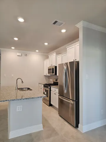 a kitchen with kitchen island a counter top space cabinets and stainless steel appliances