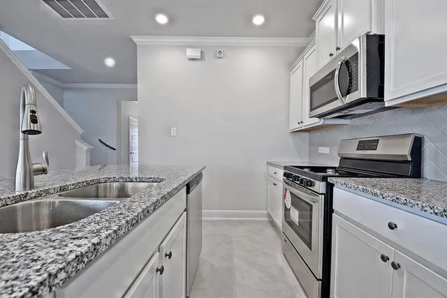 a kitchen with stainless steel appliances granite countertop a sink stove and microwave