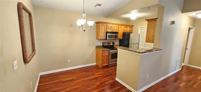 a view of a room with wooden floor and electronic appliances