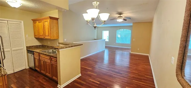 a kitchen with a stove chandelier and wooden floor