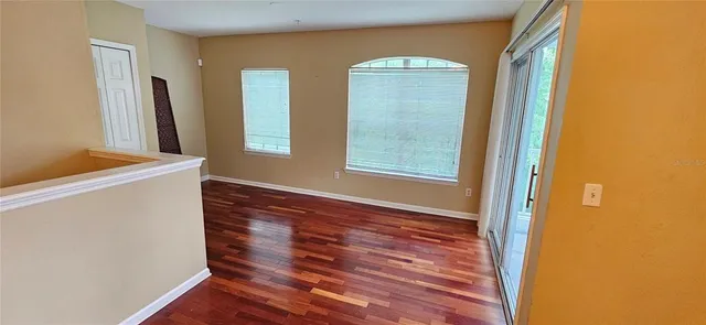 a view of hallway with window and wooden floor