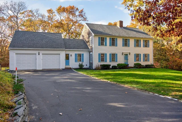 a front view of a house with a yard and trees