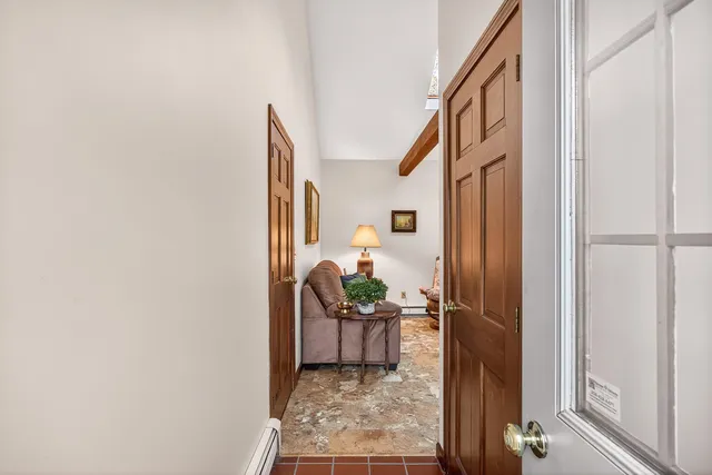 a view of a hallway and a livingroom with entryway