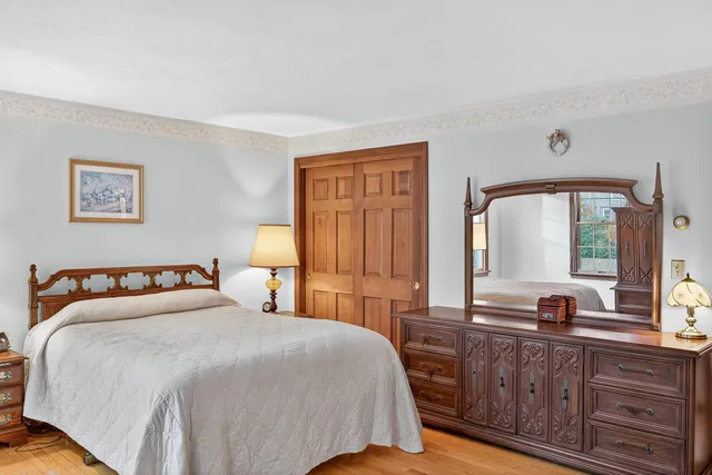 a bedroom with a large bed and a large mirror