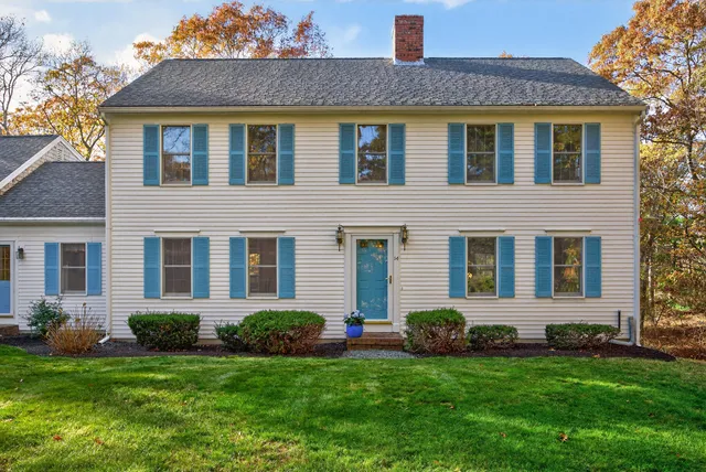 a view of a house with a yard and pathway
