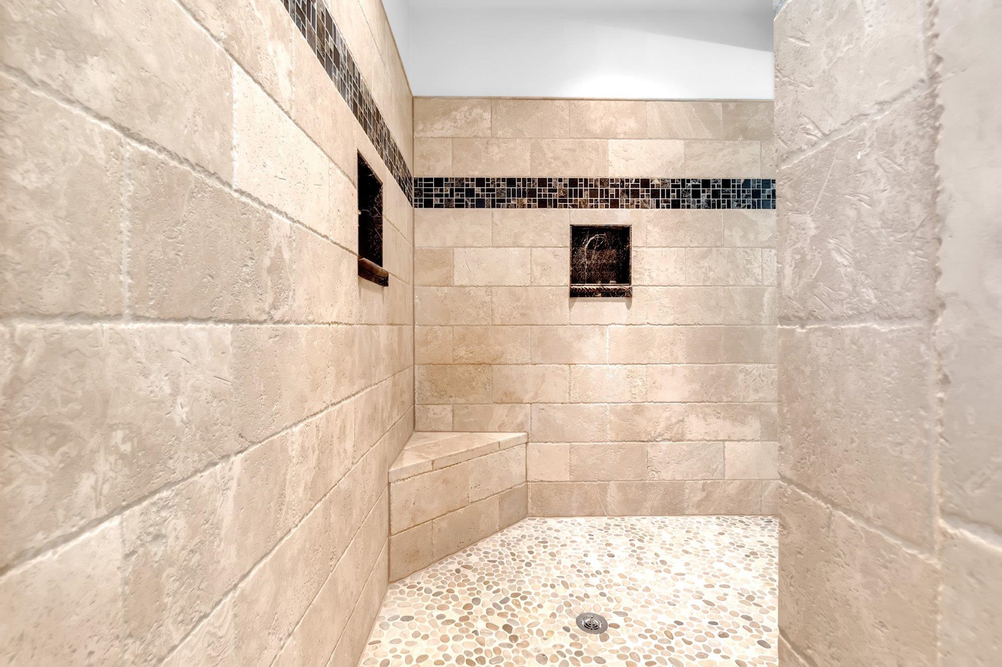 3246 North Hartwell Ridge Drive Collierville, TN 38017 - Photo 26 of 40 Tiled shower enclosure featuring a pebble floor, built-in bench, and dual recessed niches