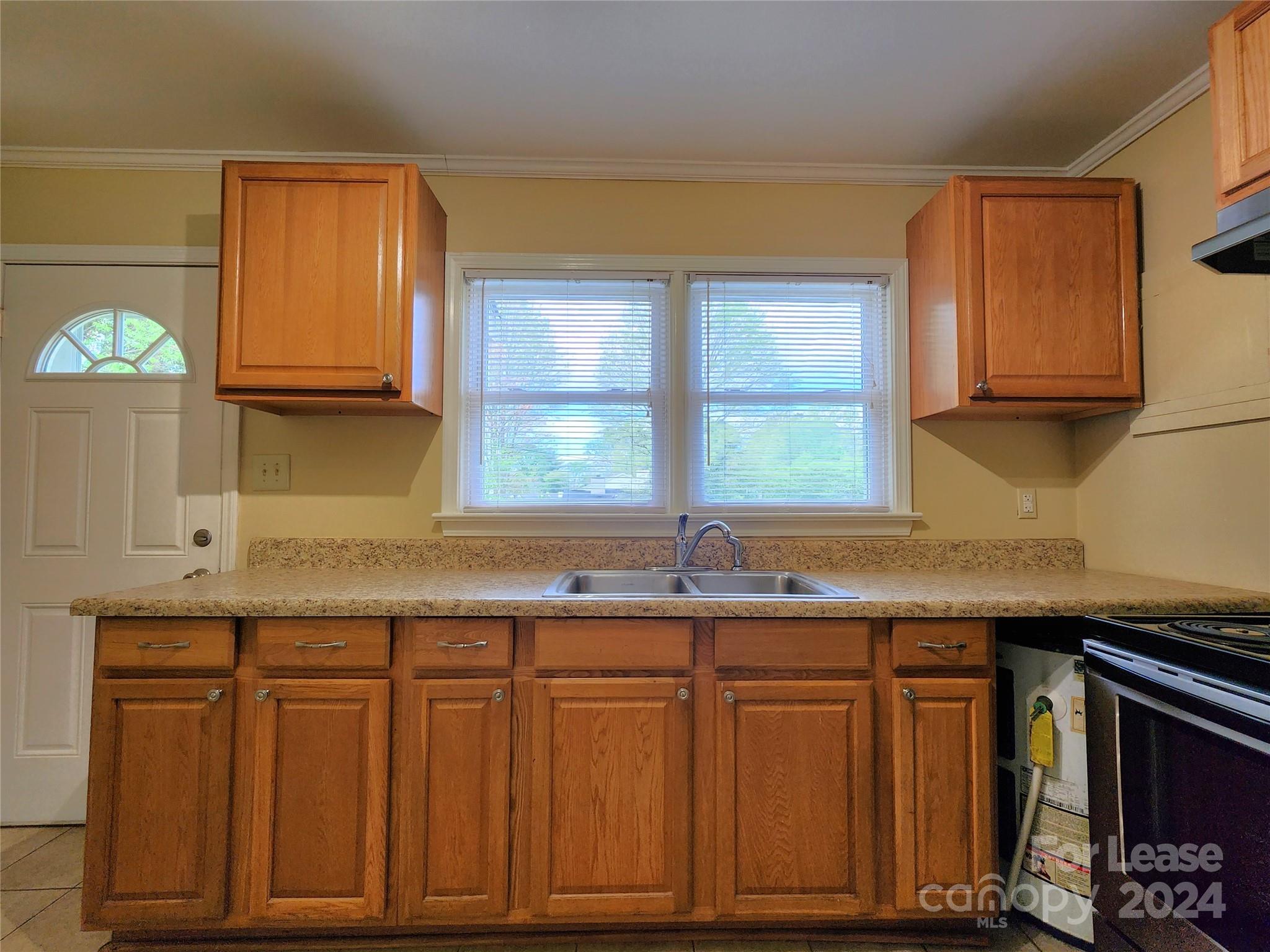 2117 Oakdale Road Charlotte, NC 28216 - Photo 3 of 20 a kitchen with granite countertop wooden cabinets a sink and a window