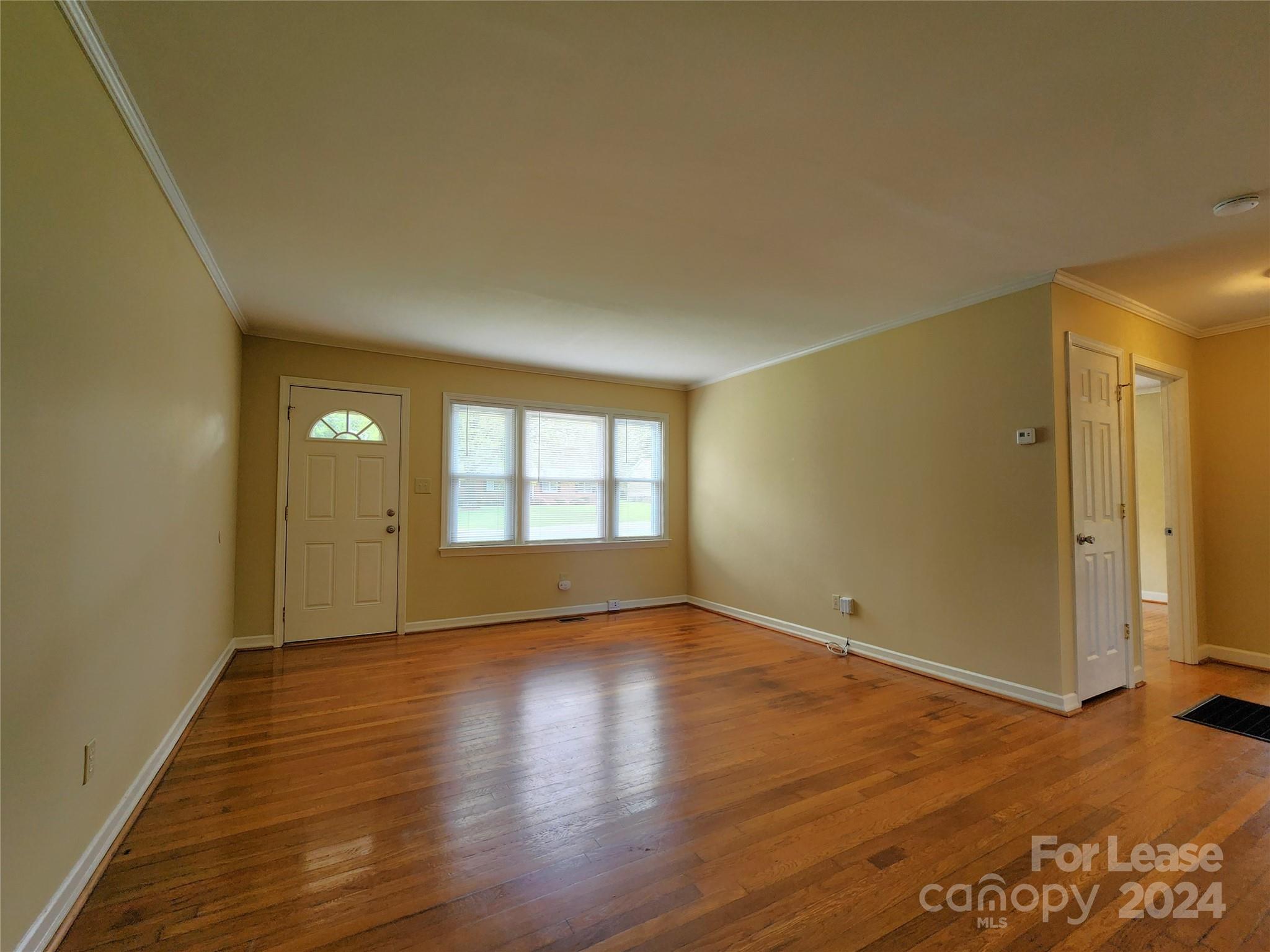 2117 Oakdale Road Charlotte, NC 28216 - Photo 8 of 20 a view of an empty room with wooden floor and a window