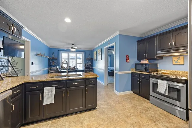 a kitchen with stainless steel appliances granite countertop a stove a sink dishwasher and a refrigerator