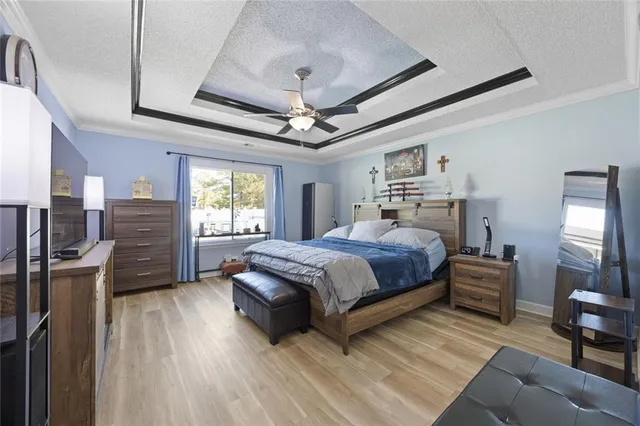 a bedroom with a bed wooden floor and window