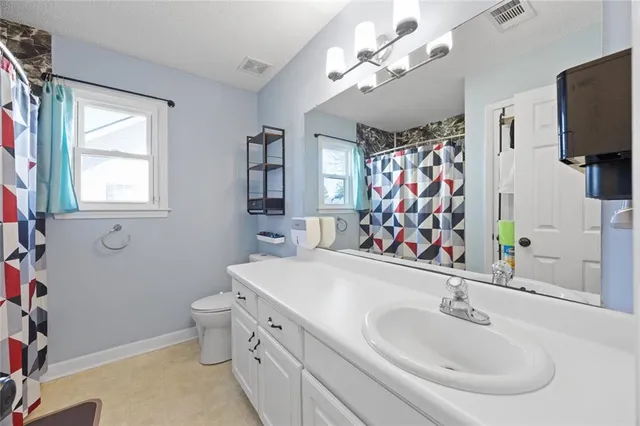 a bathroom with a sink a toilet and a mirror