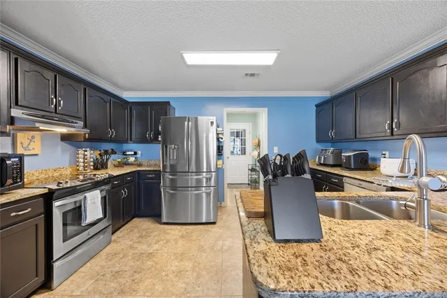a kitchen with a refrigerator stove top oven and sink