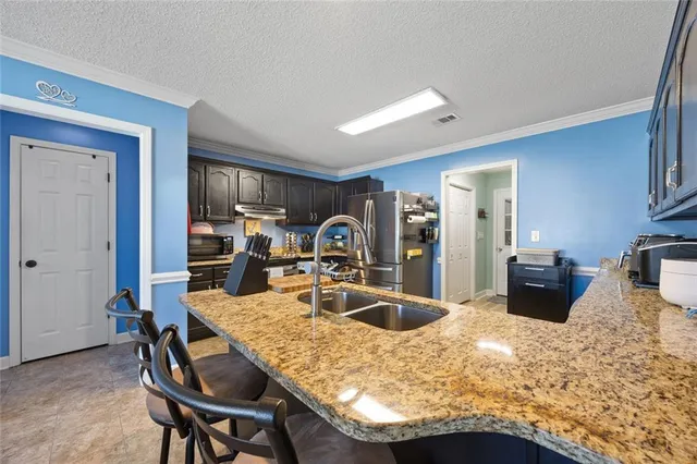 a kitchen with granite countertop a table and chairs in it